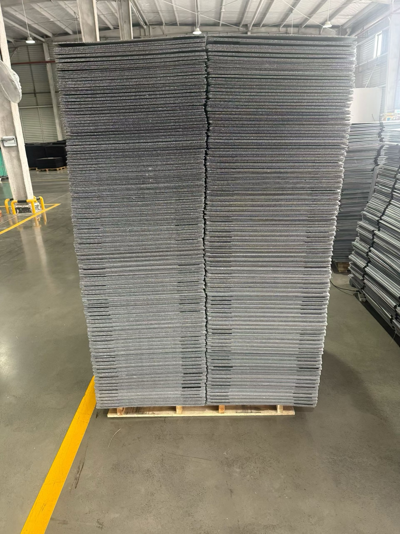 Grey PP hollow sheets stacked on pallet for corrugated plastic box production