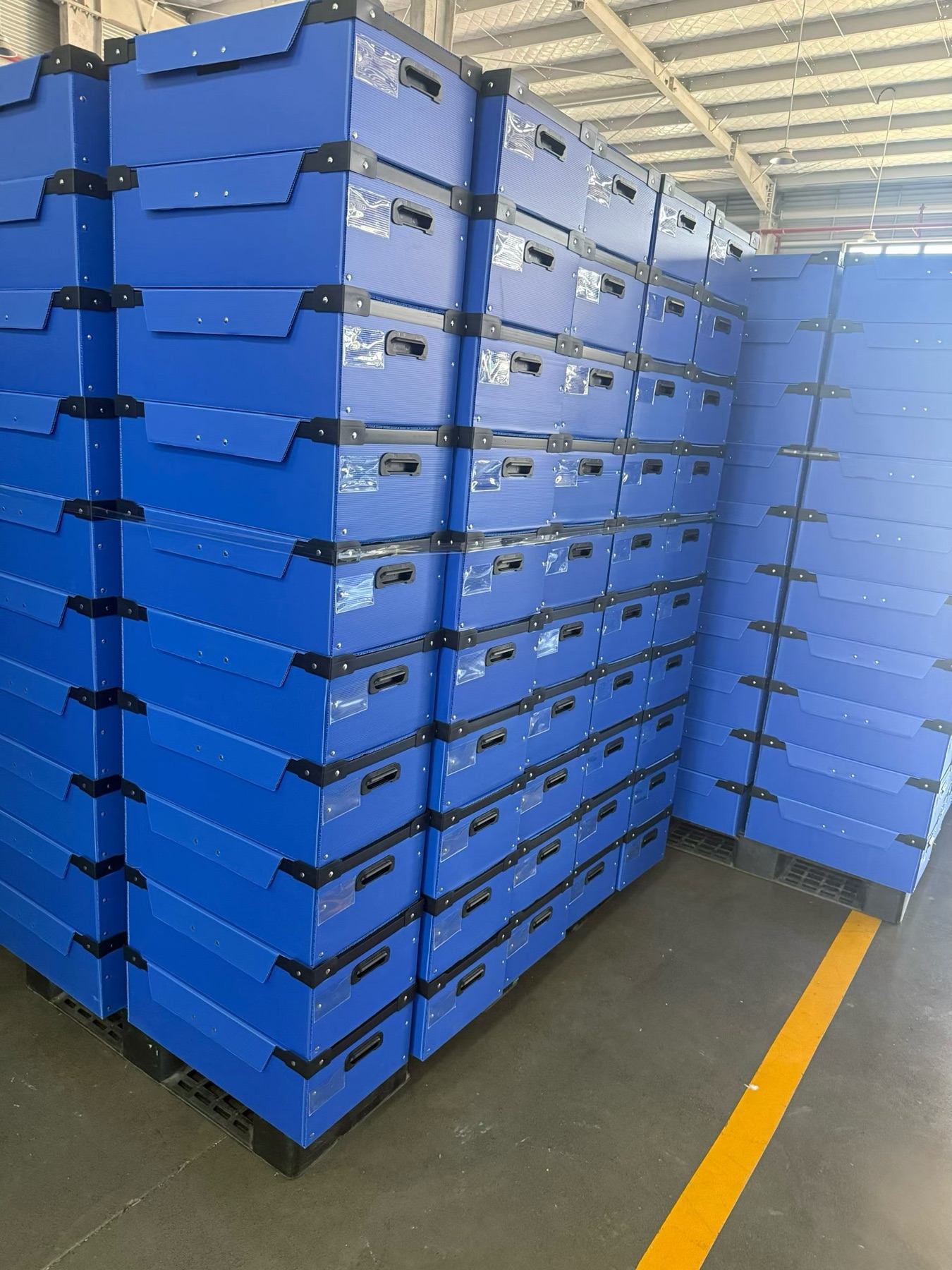 Stacks of assembled blue corrugated plastic boxes.
