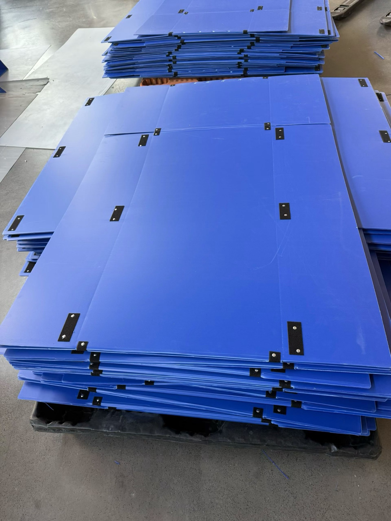 Close view of stacked blue flat-pack PP corrugated box panels