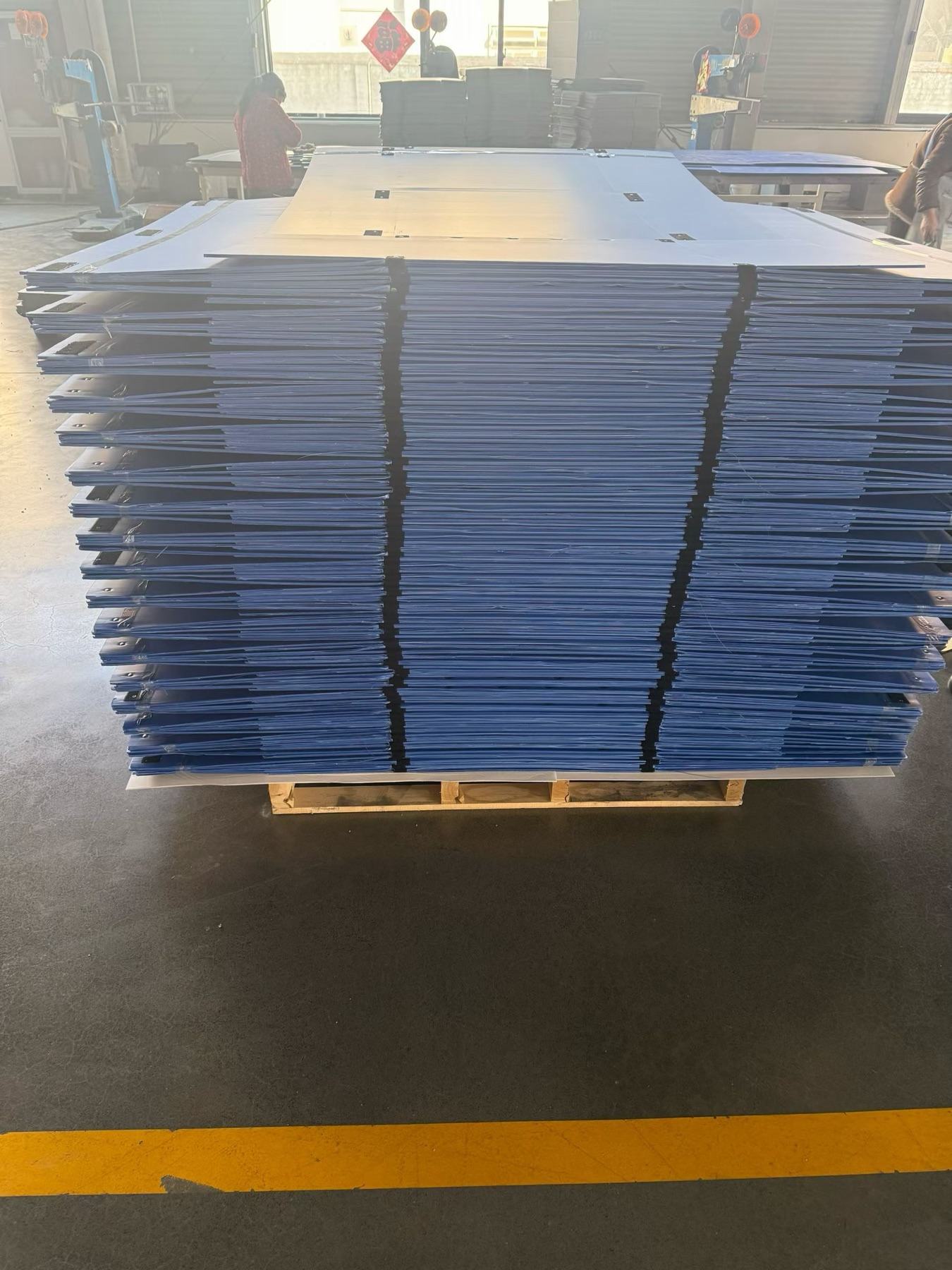 Pallet quantity of blue PP corrugated box blanks in the workshop