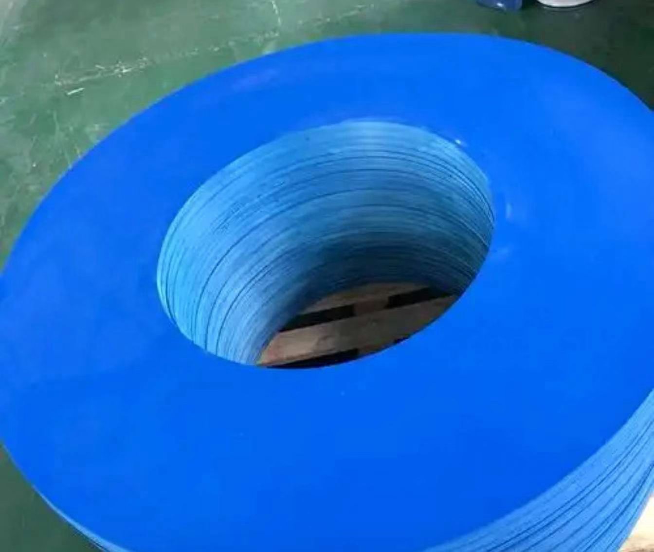 Stacked circular blue PP sheet pads with central holes